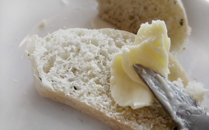 Butter being spread on a slice of bread