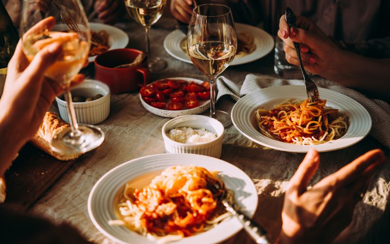 A dinner party, pasta in bowls wine glasses